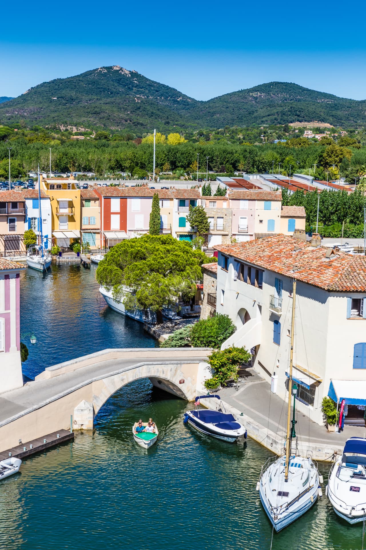 Vue aérienne des canaux de Port Grimaud, avec leurs maisons colorées, leurs bateaux et un petit pont en pierre